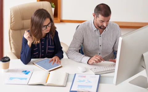 Disorganised receipts and documents on desk with frustrated business owner